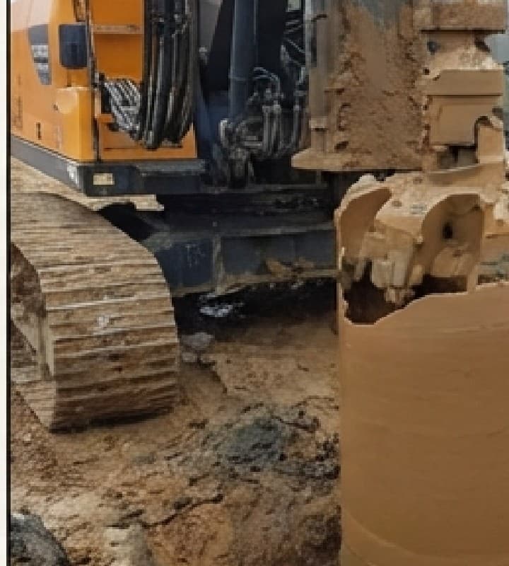 מקדח קידוח כבד עם צינור מגן (קייסינג) בעת קידוח כלונס באתר בנייה