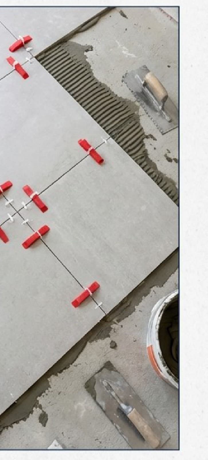 התקנת ריצוף חוץ עם מפלסי יישור אדומים (Tile Leveling System) ודבק מסורק על גבי מצע בטון