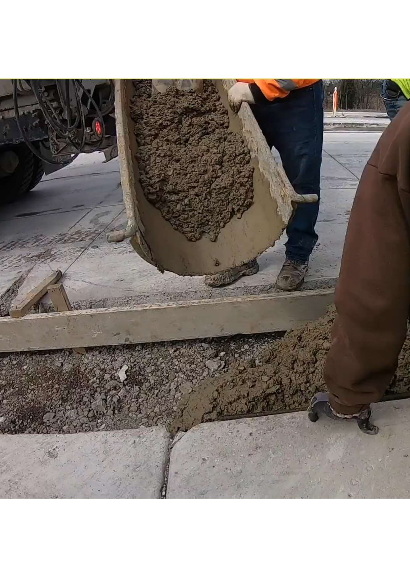פועלי בניין יוצקים בטון ממערבל מתנייע לתוך תבנית עבודות פיתוח באתר בנייה